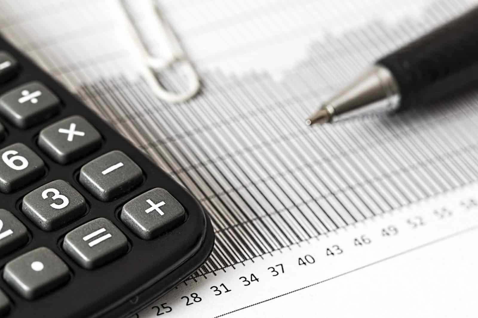 A calculator and a ruler on a wooden surface, representing financial calculations and measurements.