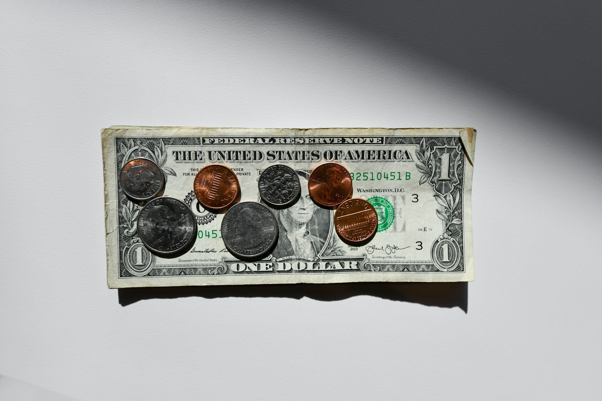 Photo of 1 dollar bill with change on top of it
